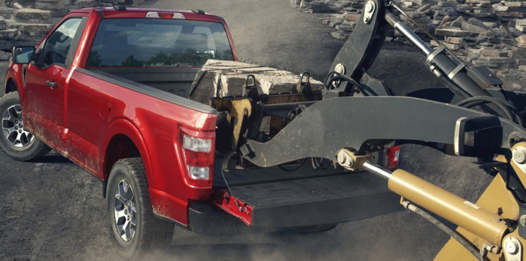 Concrete scrap is loaded into the bedliner of a Ford F-150.