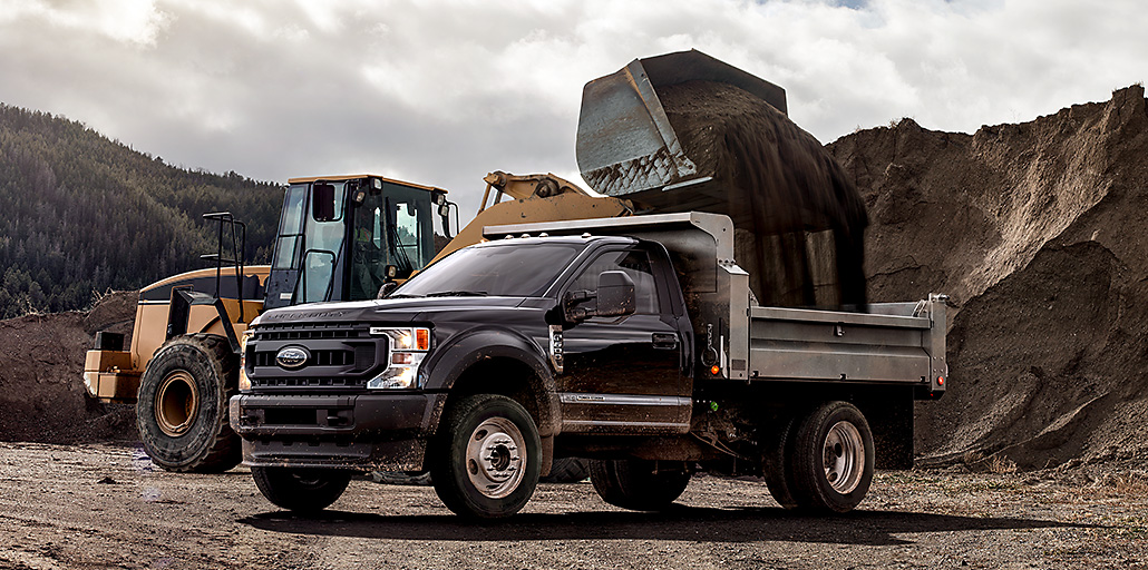 Ford Super Duty chassis dump body filled with dirt.